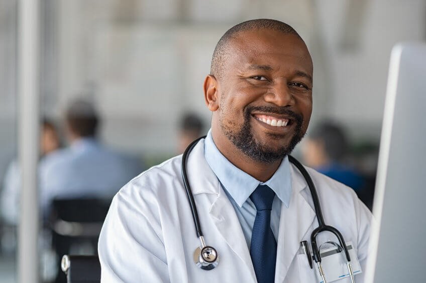 An African American male doctor smiling straight on