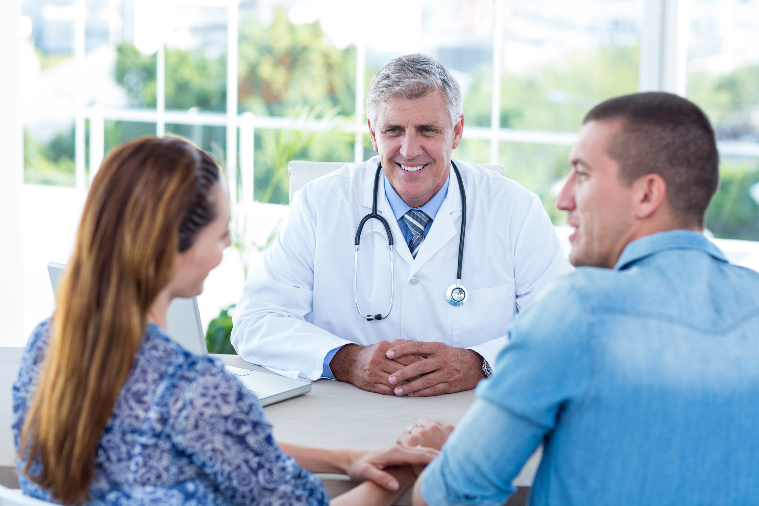 A kind doctor meeting with a young couple about their health during a doctor’s appointment