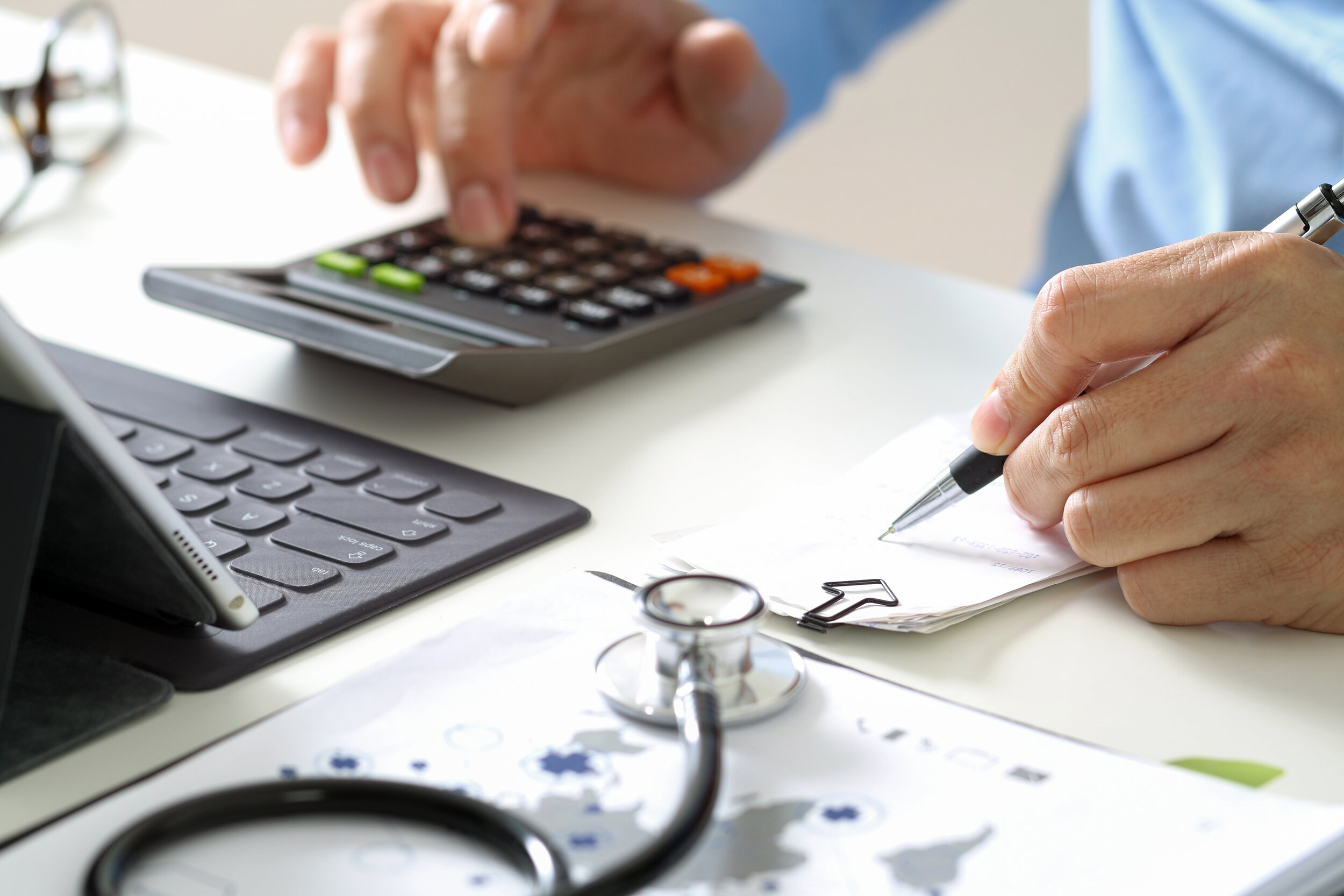 A primary care physician calculating fees from prescriptions and administered tests he gave to his patient