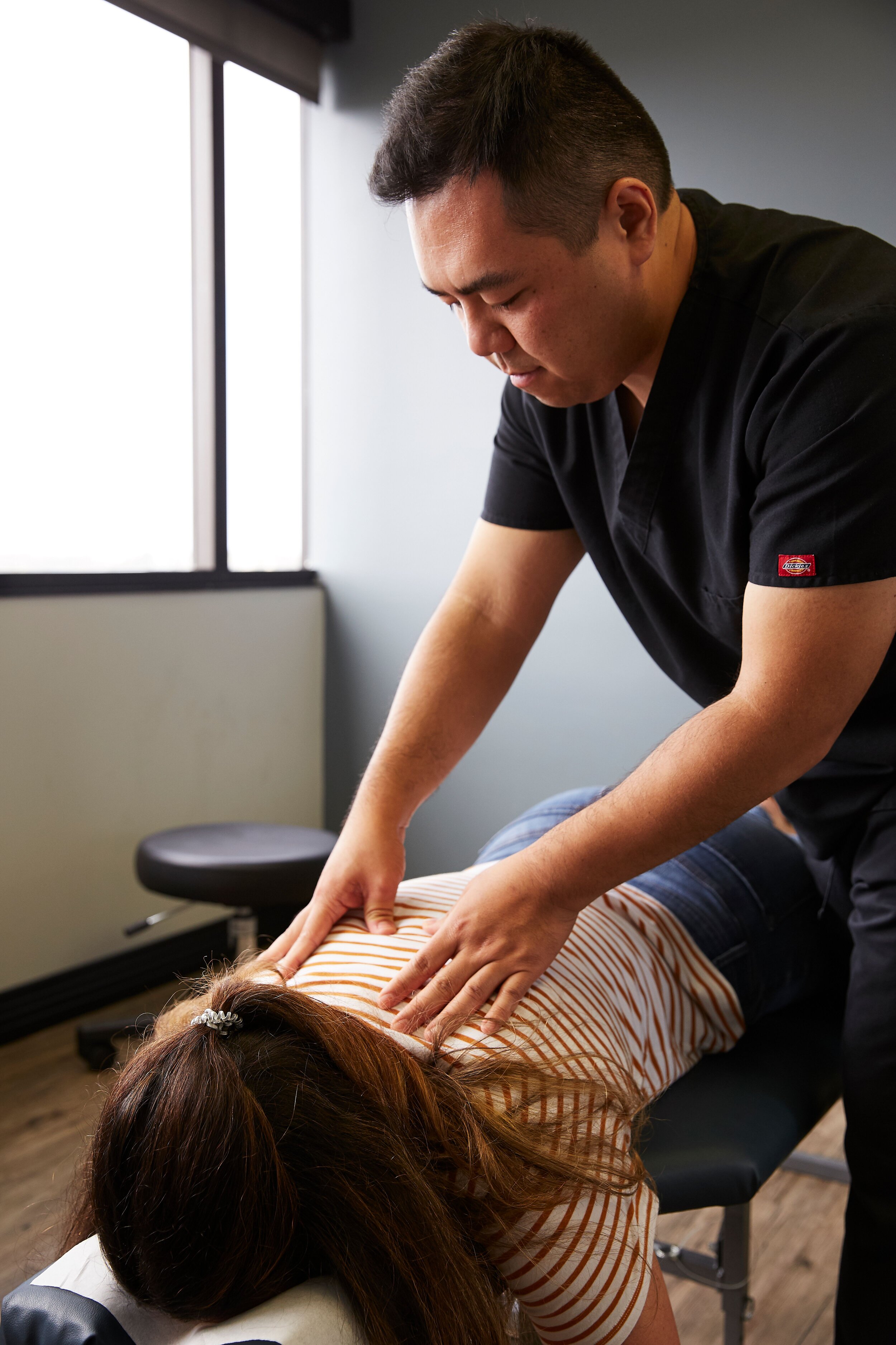 Dr. Ben Pun, D.C. (CHIROPRACTOR) giving a chiropractic adjustment to an Elevated Health patient.