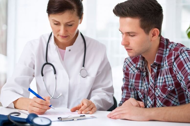 Female medical doctor consulting with a patient and assisting with medical paperwork