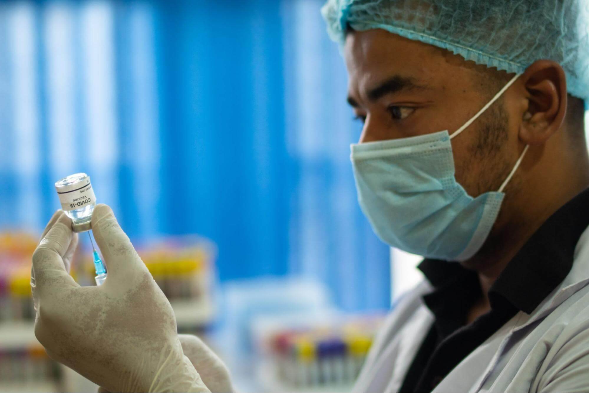 male medical technician preparing a vaccine for a patient