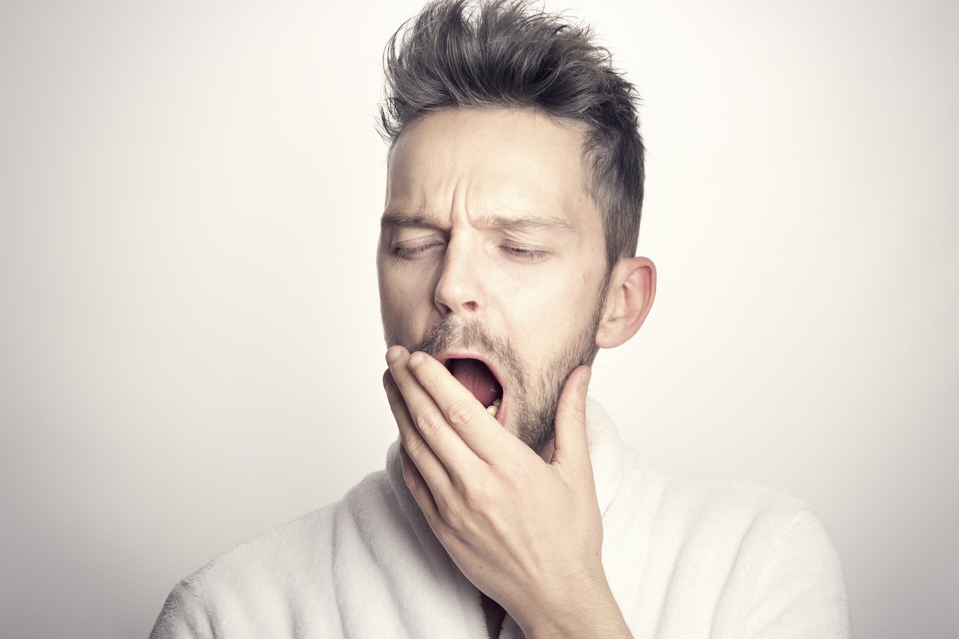 A man covering his yawn with his hand