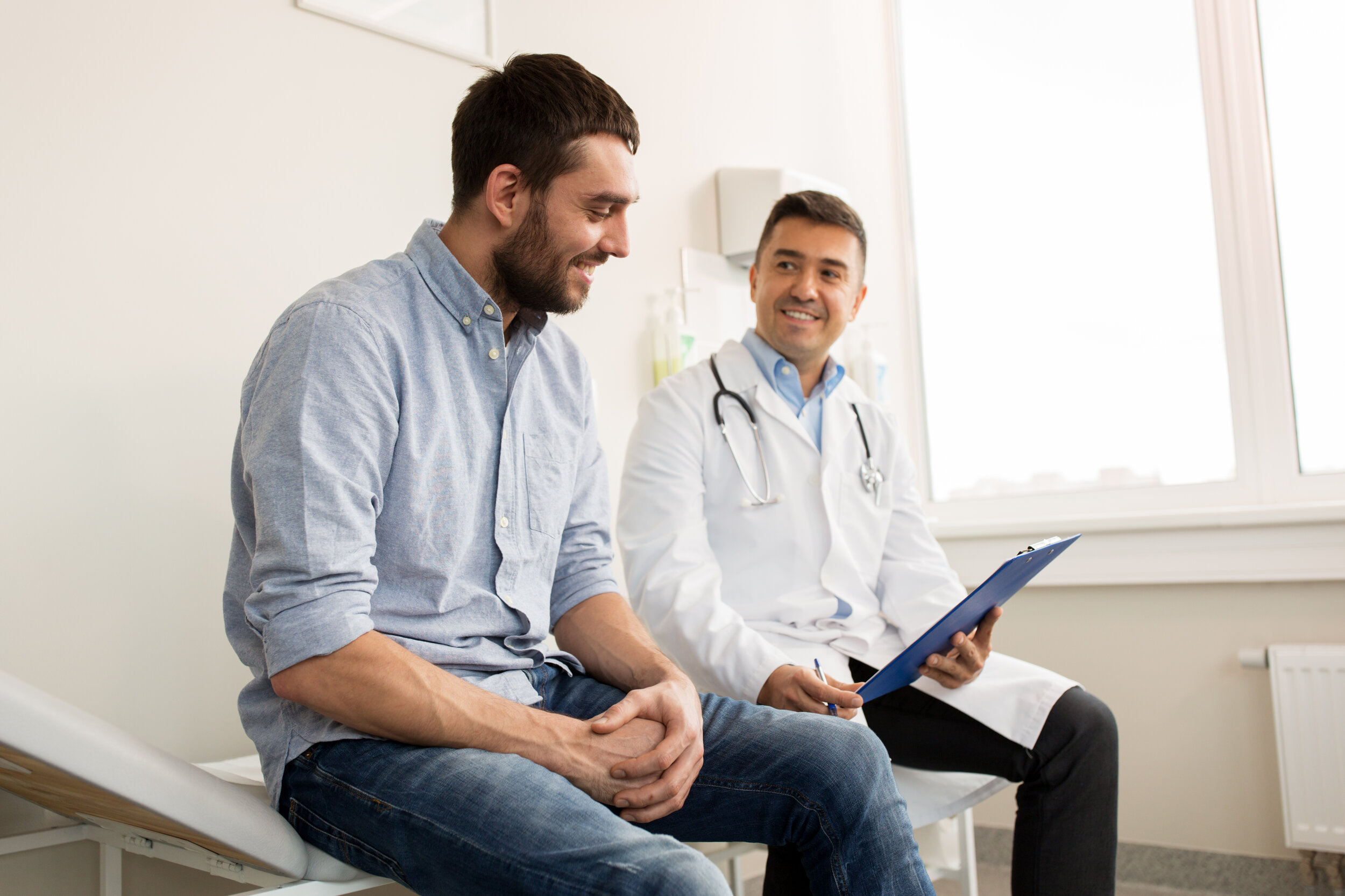 A male physician talking to a patient about his primary care membership